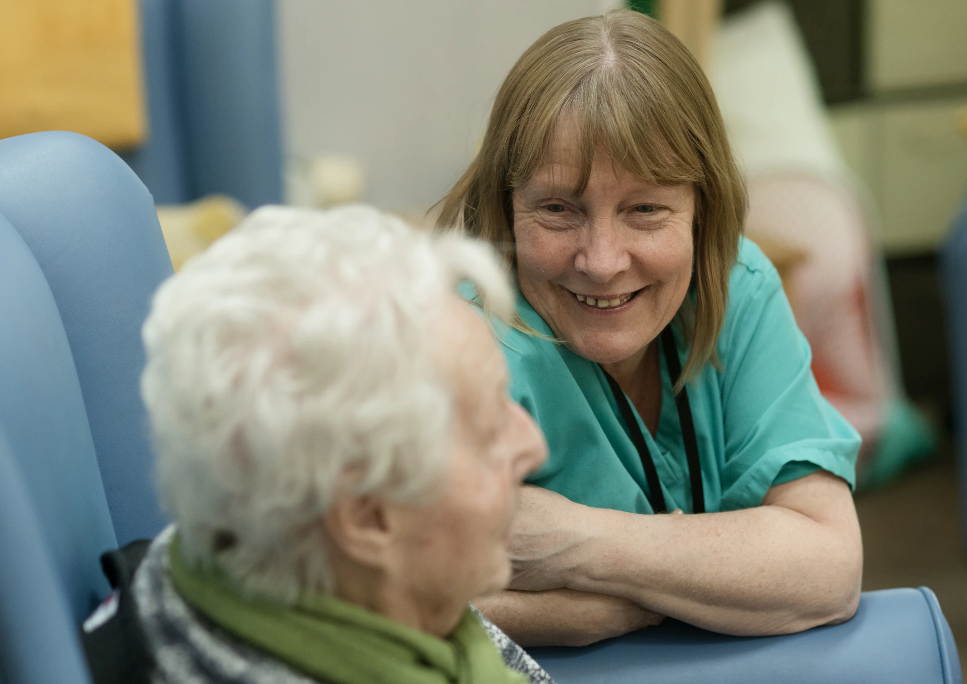 Carer supporting an elderly person in their chair